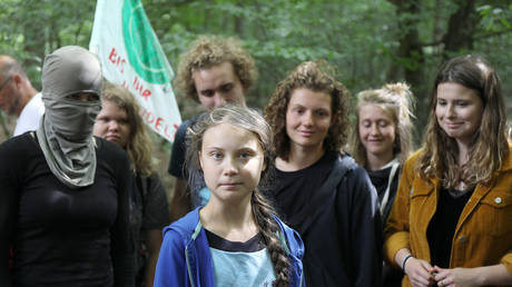 Swedish teenage climate campaigner Greta Thunberg (C) stands next to German climate activists as she visits the Hambach Forest, Germany, on August 10, 2019.