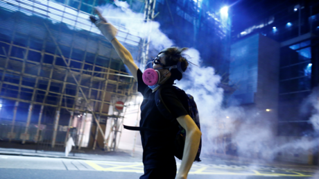 An anti-extradition bill protester throws a tear gas cartridge during clashes with police in Sham Shui Po in Hong Kong, China August 14, 2019. © REUTERS/Thomas Peter