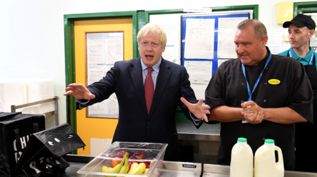 British Prime Minister Boris Johnson (L) speaks to kitchen staff as he visits Torbay Hospital in Torquay, southwest England, on August 23, 2019. © AFP / Finnbarr Webster