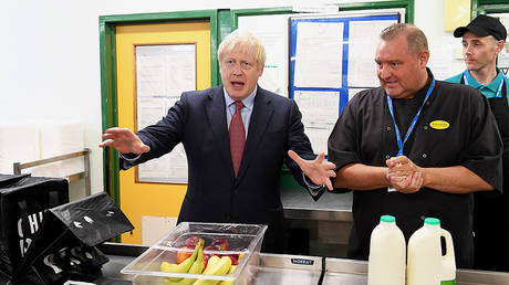 British Prime Minister Boris Johnson (L) speaks to kitchen staff as he visits Torbay Hospital in Torquay, southwest England, on August 23, 2019. © AFP / Finnbarr Webster