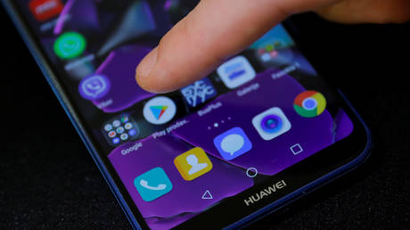 Man points a finger to the Google Play app logo on his Huawei smartphone © Reuters / Marko Djurica