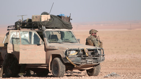 FILE PHOTO: A US fighter stands near a military vehicle, north of Raqqa city © Rodi Said