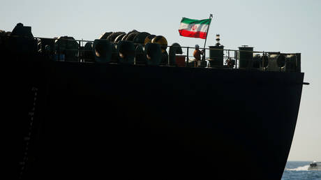 A crew member raises the Iranian flag on Iranian oil tanker Adrian Darya 1, previously named Grace 1, in the Strait of Gibraltar, Spain. File photo.