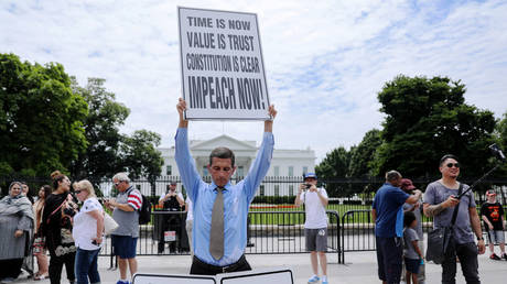 Steve Swanson protests in silence with a sign over his head reading “Impeach Now!” in front of the White House in Washington, U.S. June 19, 2019.  © REUTERS/Jonathan Ernst