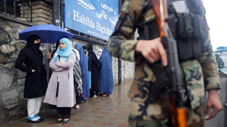 FILE PHOTO: An Afghan policeman stands guard at a polling station in Kabul.