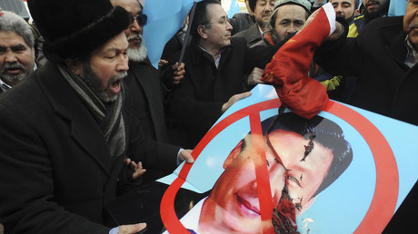 Ethnic Uyghur demonstrators hold a defaced poster of China's Vice-President Xi Jinping during a protest in Ankara February 21, 2012 ©