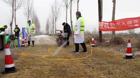 Workers in protective suits are seen at a checkpoint near a farm where African swine fever was detected in Hebei province, China on February 26, 2019.

