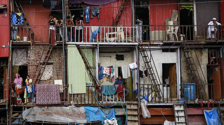 Residents stand in their shanties at a slum in northern suburb of Mumbai, India © Reuters / Danish Siddiqui
