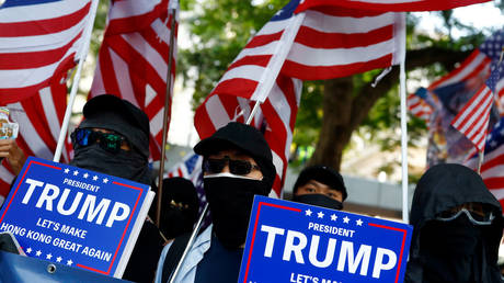 Masked protesters hold placards during the “March of Gratitude to the US” event in Central, Hong Kong, China December 1, 2019. © Reuters / Thomas Peter