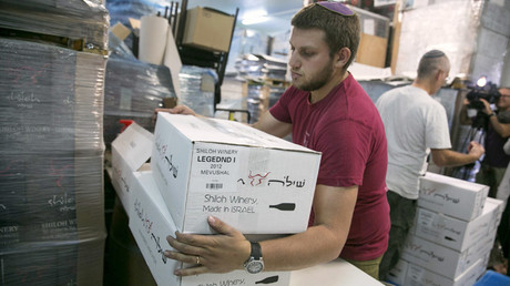 A worker carries boxes containing wine bottles for export at Shiloh Wineries, north of the West Bank city of Ramallah November 8, 2015. © Baz Ratner