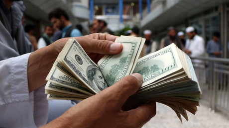 FILE PHOTO: A money changer counts US dollar banknotes at a market in Herat province, Afghanistan, on June 3, 2018. © Jalil Ahmad