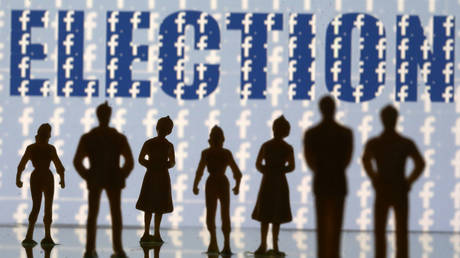 Small figures stand in front of Facebook logos and an election sign © Reuters / Dado Ruvic / Illustration
