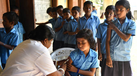 FILE PHOTO: An Indian health worker injects a measles and rubella (MR) vaccine to a student at a school in Morigoan, India, on September 4, 2018. © AFP / Biju Boro


