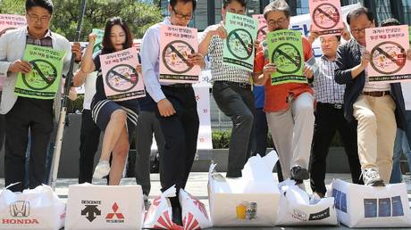 South Korean merchants stomp on boxes bearing the logos of Japanese manufacturers at a demonstration, July 5, 2019.