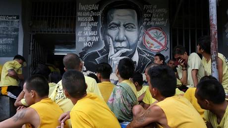 A mural of Philippines President Rodrigo Duterte overlooks prisoners inside the Manila City Jail, October 16, 2017. It reads: "Steer away from illegal drugs to save your life and in turn, will save the country's."