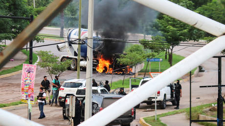 Cartel gunmen are seen near a burning truck during clashes with federal forces following the detention of Ovidio Guzman, son of drug kingpin Joaquin "El Chapo" Guzman, in Culiacan, Sinaloa state, Mexico, October 17, 2019.
