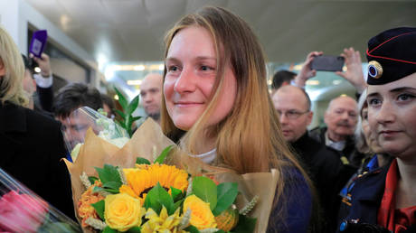 Maria Butina, who was released from a Florida prison and then deported by U.S. immigration officials, holds flowers upon her arrival at Sheremetyevo International Airport outside Moscow, Russia October 26, 2019. © REUTERS/Tatyana Makeyeva