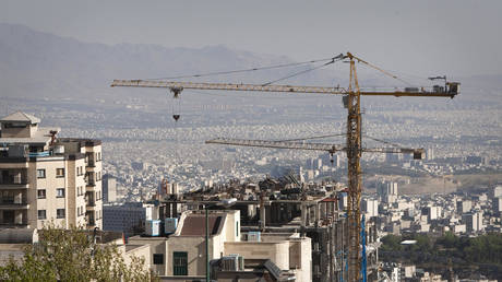 FILE PHOTO: Construction cranes work on a high rise buildings in Tehran.