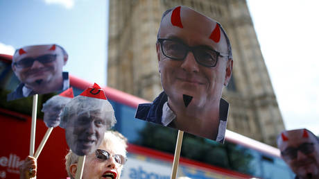 FILE PHOTO: Anti-Brexit protesters hold signs featuring Dominic Cummings in London © Reuters / Henry Nicholls