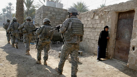 FILE PHOTO: US Army soldiers walk through a village during a search for weapons caches and insurgents near Baquba, Iraq, December 15, 2007.