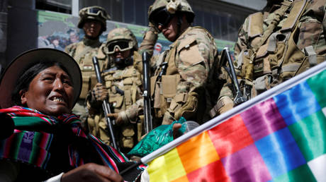 A pro-Morales demonstrator and armed members of the security forces during clashes in La Paz, Bolivia, November 15, 2019.