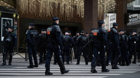 CRS riot police and police officers stand outside the Galleries Lafayette in Paris, on November 17, 2019.