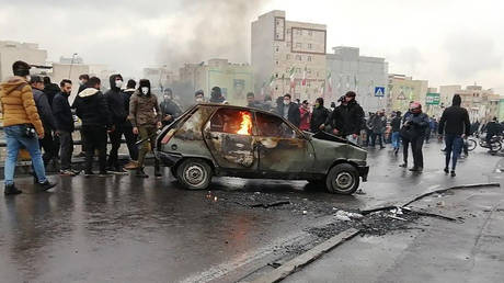 Iranian protesters gather around a burning car during a demonstration against an increase in gasoline prices in the capital Tehran, on November 16, 2019 © AFP