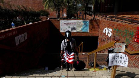 An anti-government protester, with a U.S. flag draped at his waist, leaves the Union building at the besieged Hong Kong Polytechnic University (PolyU) in Hong Kong, China, November 20, 2019. © REUTERS/Thomas Peter