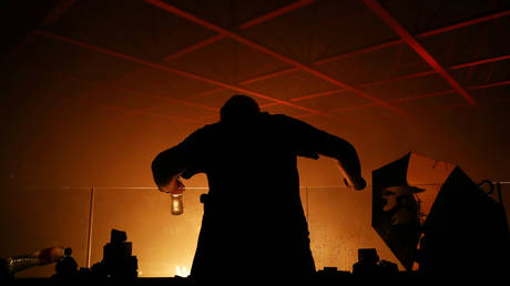 FILE PHOTO: An anti-government protester is seen at the Hong Kong Polytechnic University (PolyU) during a fire in Hong Kong, China, on November 18, 2019.