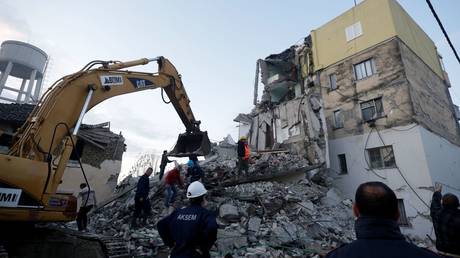 Emergency personnel work near a damaged building in Thumane. © REUTERS/Florian Goga