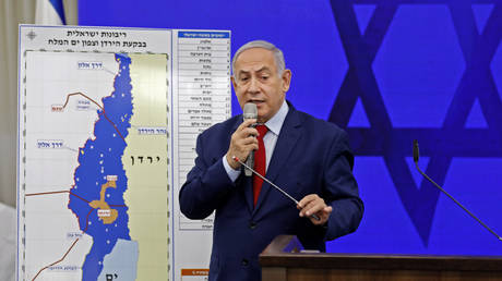 Benjamin Netanyahu speaks before a map of the Jordan Valley, which he wants to annex. © AFP / Menahem Kahana