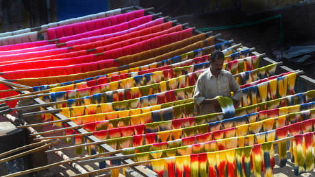A Pakistani worker dries fabric threads after dyeing them at a factory in Lahore on February 11, 2019. ©  AFP / Arif Ali