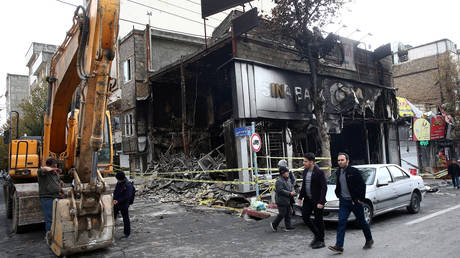 © People walk near a burnt bank, after protests against increased fuel prices, in Tehran, Iran November 20, 2019. © Reuters / WANA / Nazanin Tabatabaee