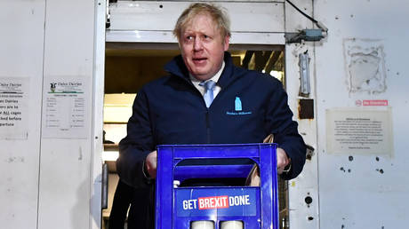 Prime Minister Boris Johnson carries a crate of milk to deliver to customers © Reuters / Ben Stansall / Pool
