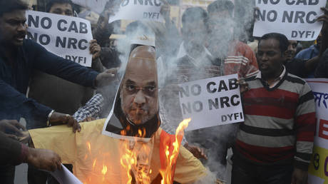 Protesters burn an effigy of India's Home Minister Amit Shah during a demonstration against the Citizenship Amendment Bill in Siliguri, West Bengal