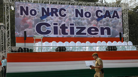 A policeman walks past a hoarding at the venue of a protest rally against a new citizenship law in Kolkata, India December 20, 2019.