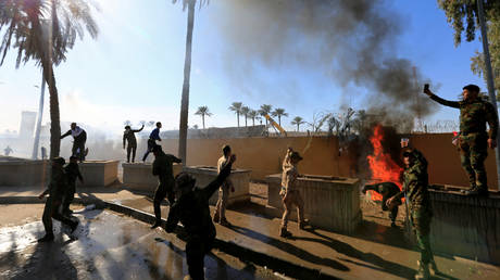 Hashd al-Shaabi (paramilitary forces) fighters set fire on the U.S. Embassy wall to condemn air strikes on their bases, in Baghdad, Iraq December 31, 2019.
