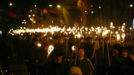 Activists of Ukrainian nationalist parties hold torches as they take part in a rally to mark the anniversary of the birth of Bandera in Kiev
