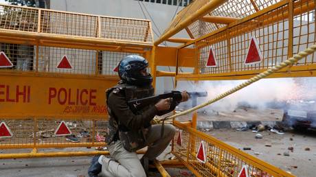 A police officer fires a tear gas shell towards protestors during a protest against the Citizenship Amendment Bill, outside the Jamia Millia Islamia University in New Delhi, India, December 13, 2019.