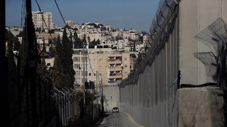 A car drives in the Palestinian neighbourhood of Ras al-Amud, next to an Israeli barrier that separates it from neighbouring Abu Dis in the Israeli-occupied West Bank, east of Jerusalem January 26, 2020. © REUTERS/Ammar Awad