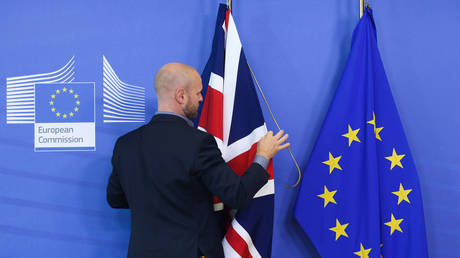 A staff member arranges flags of the UK and the EU © Global Look Press / Zheng Huansong