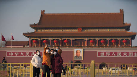 Visitors wearing masks take selfies in front of Beijing's Tiananmen Gate, January 30, 2020 © Reuters / Stringer