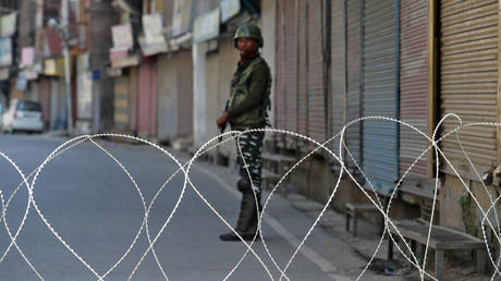 FILE PHOTO An Indian security force personnel stands guard in front of the closed shops during restrictions following scrapping of the special constitutional status for Kashmir by the Indian government, in Srinagar, September 10, 2019.