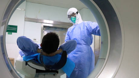A medical worker and a patient at the Zhongnan Hospital of Wuhan University following an outbreak of the new coronavirus in Wuhan, Hubei province, China. February 2, 2020. © China Daily / Reuters