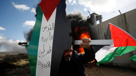 A demonstrator carries a model of a map with the colors of the Palestinian flag reading "Jerusalem is the eternal capital of Palestine" during a protest against the U.S. President Donald Trump's  peace plan in the West Bank January 31, 2020. ©  REUTERS/Mohamad Torokman