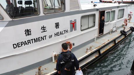 A government officer boards a Department of Health ship before it heads to the Kai Tak Cruise Terminal in Hong Kong, China, where the World Dream ship that had been denied entry to Taiwan's Kaohsiung is currently docked. February 5, 2020. © Reuters / Jessie Pang