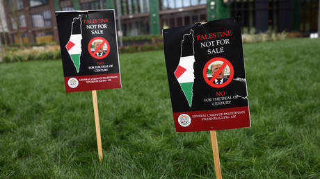 Protest signs are stuck into a lawn during a demonstration against US President Donald Trump's Middle East peace plan in London. February 1, 2020. © Reuters / Simon Dawson