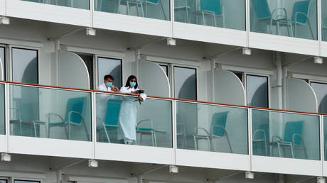 Passengers look out from a cabin of the World Dream cruise ship in Hong Kong, China February 6, 2020.