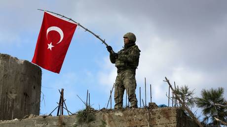 FILE PHOTO: A Turkish soldier  waving his country's national flag. © Reuters / Khalil Ashawi