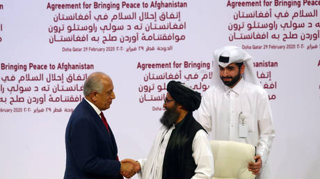 Mullah Abdul Ghani Baradar, the leader of the Taliban delegation, and Zalmay Khalilzad, US envoy for peace in Afghanistan, shake hands after signing a peace agreement in Doha, Qatar. February 29, 2020. © Ibraheem al Omari / Reuters